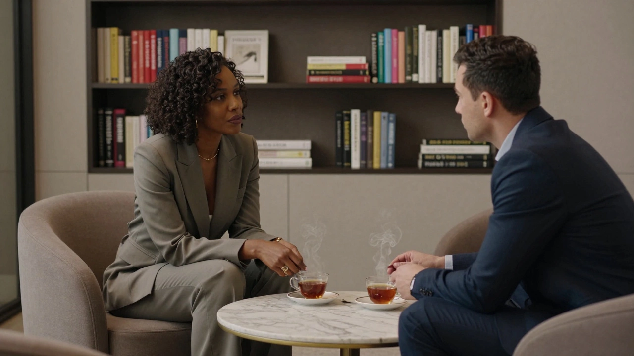 A professional African woman in a tailored suit converses quietly with a client in a minimalist villa lounge, surrounded by books on global affairs.